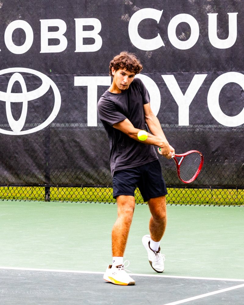 Aidan Peskin hitting a two-handed backhand at contact